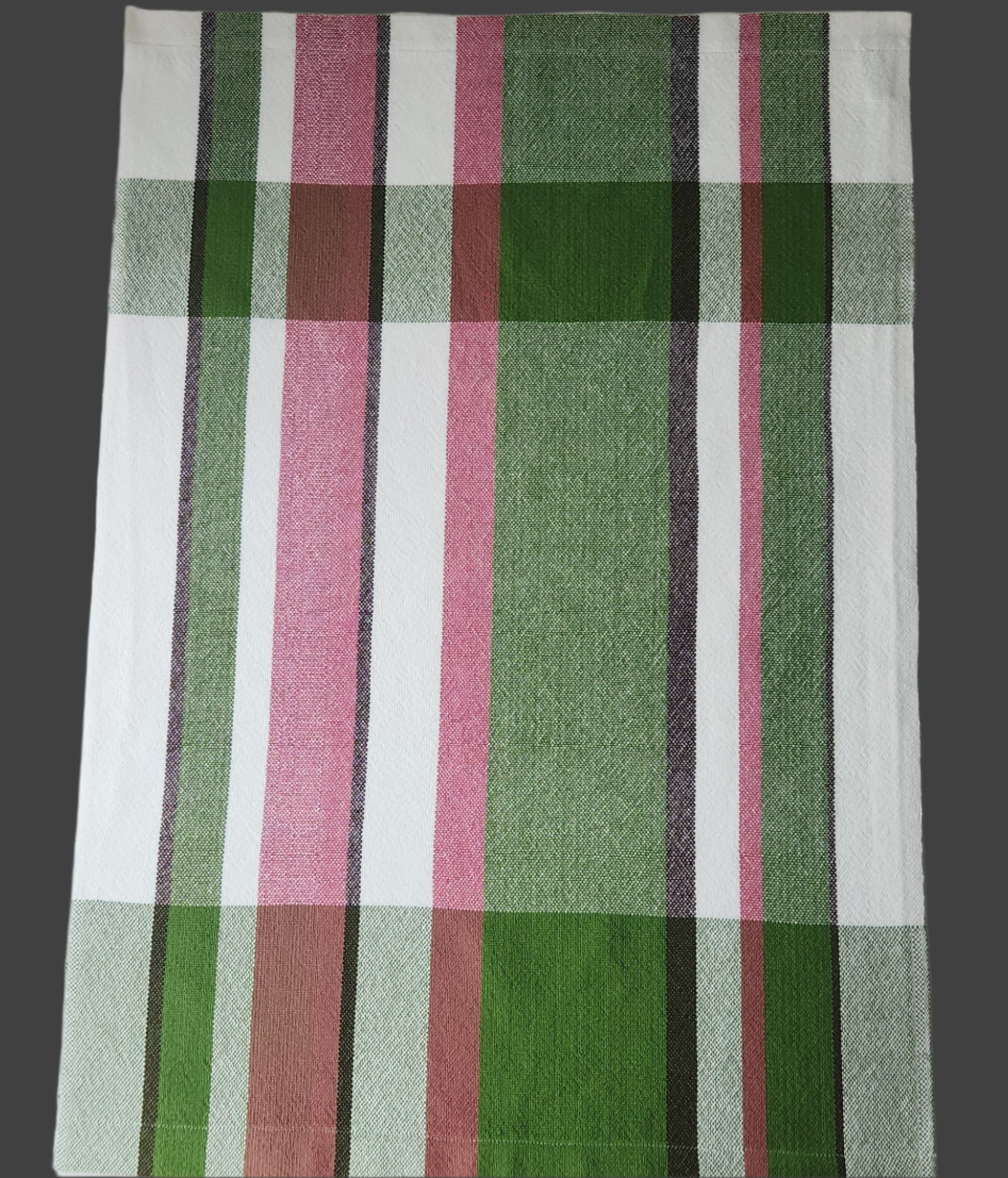 Plaid fabric with green, pink, and white stripes on a white background