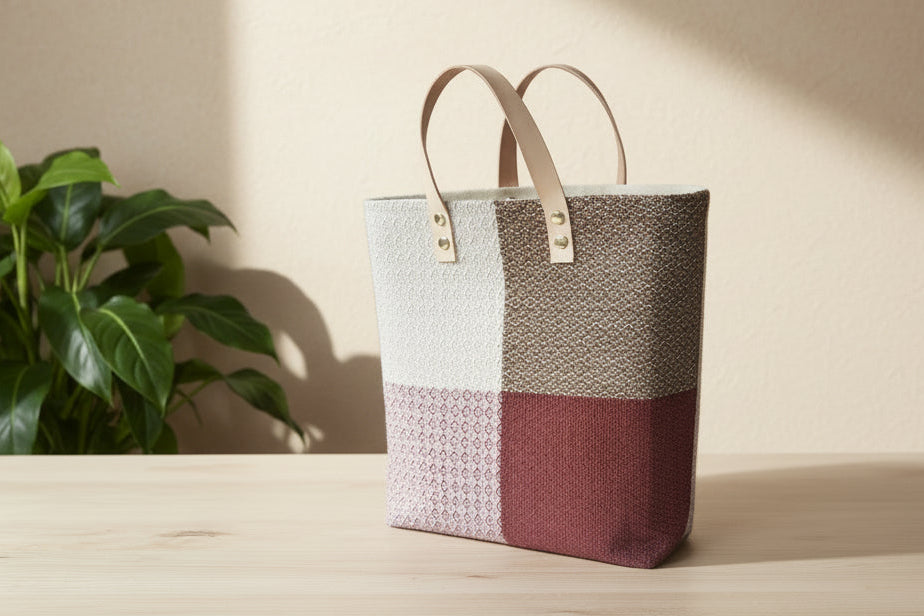 Plaid handbag on a white surface with a neutral background