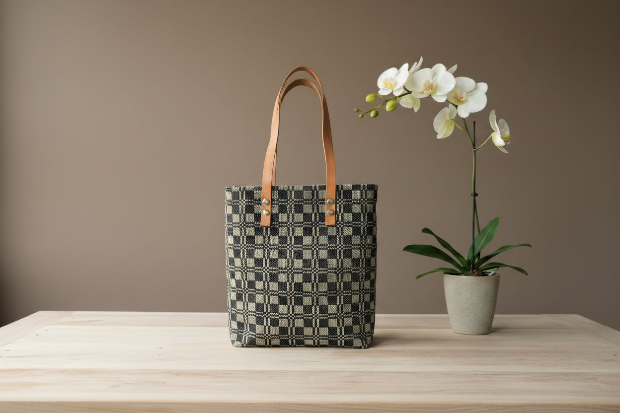Patterned handbag with natural leather handle on a white surface